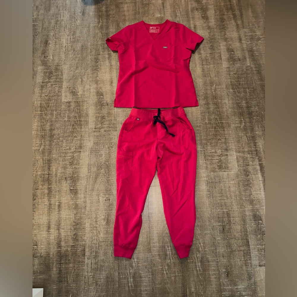 Hot pink figs scrubs set with purple tie on pants.